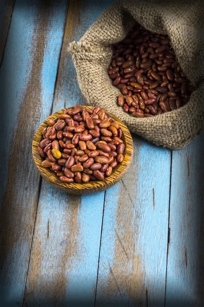 Rote Bohnen mit Kochlöffel auf dem blauen Holztisch — Stockfoto