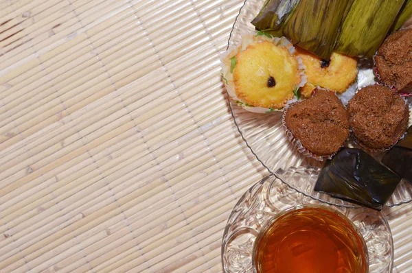 Taza de té y pastel en la mesa de desayuno de bambú — Foto de Stock