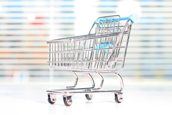 Shopping cart on a white table. — Stock Photo, Image