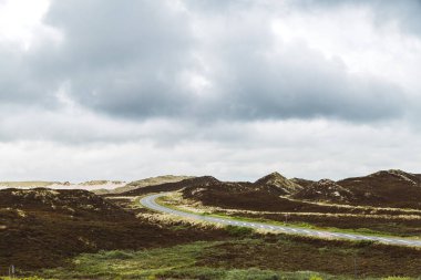 Sylt 'deki kum tepelerinden geçen uzun bir yol.