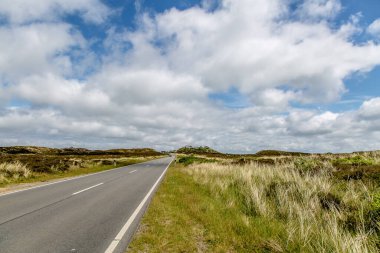 Sylt 'deki kum tepelerinden geçen uzun bir yol.