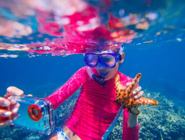 Foto subaquática da menina com uma estrela do mar — Fotografia de Stock