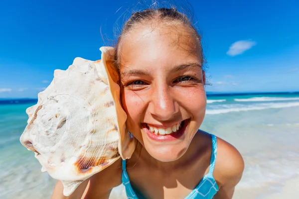 Flicka med skal på stranden — Stockfoto