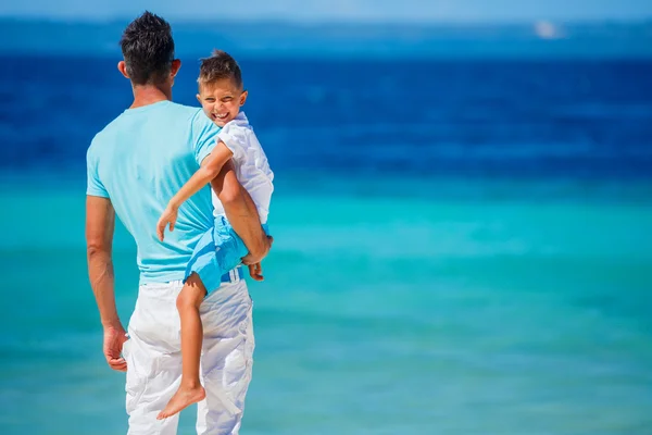 Far och son leker på stranden. — Stockfoto