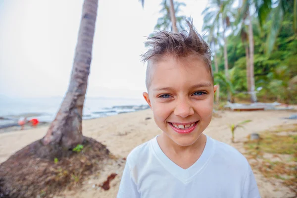 Мальчик на тропическом пляже — стоковое фото