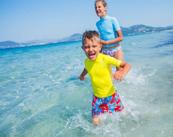 Deux enfants heureux jouant sur la plage — Photo