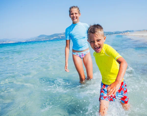 Deux enfants heureux jouant sur la plage — Photo