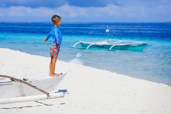 Хлопчик у човні на пляжі — стокове фото