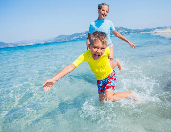 Zwei glückliche Kinder spielen am Strand — Stockfoto