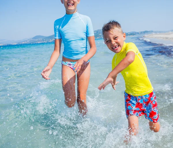 Duas crianças felizes brincando na praia — Fotografia de Stock