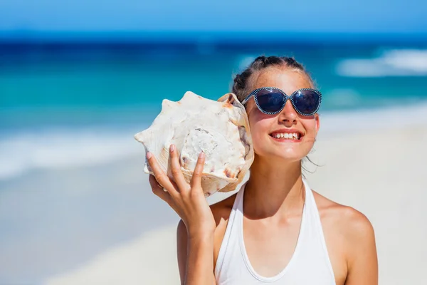 Flicka med skal på stranden — Stockfoto