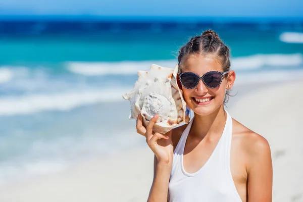 Flicka med skal på stranden — Stockfoto