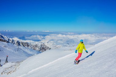 Kız snowboardcu kış kayak merkezinde eğleniyor..