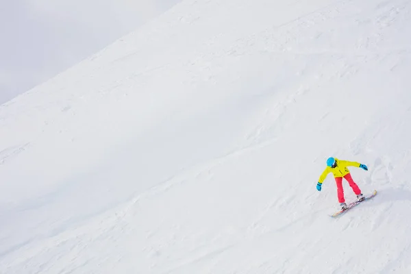 Dziewczyna snowboardzista zabawy w ośrodku narciarskim zimą. — Zdjęcie stockowe