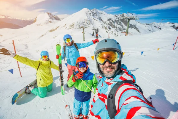 家族は山で冬の休暇を楽しんでいます。スキー、太陽、雪と楽しみ. — ストック写真