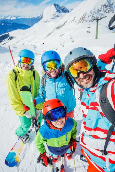 Familia disfrutando de vacaciones de invierno en las montañas. Esquí, sol, nieve y diversión. —  Fotos de Stock