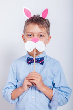 Gri arka planda tavşan kulaklı şirin bir çocuk.