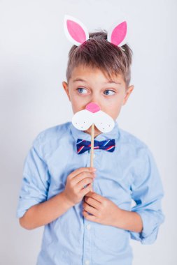 Gri arka planda tavşan kulaklı şirin bir çocuk.