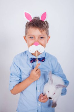 Gri arka planda tavşan kulaklı şirin bir çocuk.