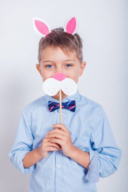 Gri arka planda tavşan kulaklı şirin bir çocuk.