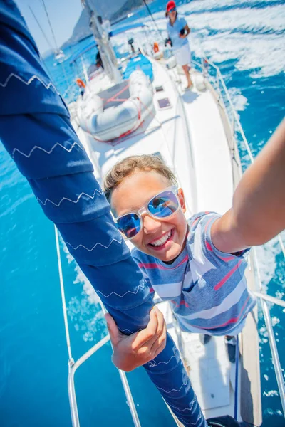 Niño a bordo de un yate de vela en un crucero de verano. Aventura de viaje, yates con niños en vacaciones en familia. — Foto de Stock