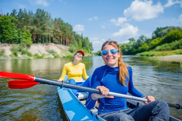 Glad flicka kajakpaddling på floden på en solig dag under sommarsemester — Stockfoto