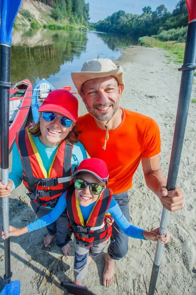 Famiglia felice con bambino godendo giro in kayak sul bellissimo fiume. Ragazzino e adolescente kayak in calda giornata estiva. Sport acquatici divertimento. — Foto Stock