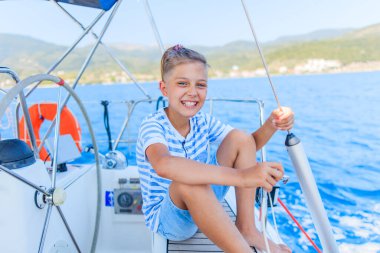 Küçük çocuk yaz gezisinde yelkenli yatında. Seyahat macerası, çocuğuyla yat gezisi..