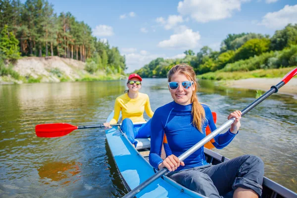 Filles heureuses kayak sur la rivière par une journée ensoleillée pendant les vacances d'été — Photo