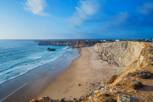 ポルトガルの海岸にあるビーチやターコイズブルーの海の上の岩の崖のアーチ. — ストック写真
