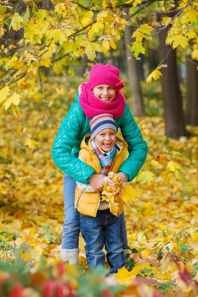 Bambini carini con foglie autunnali — Foto Stock