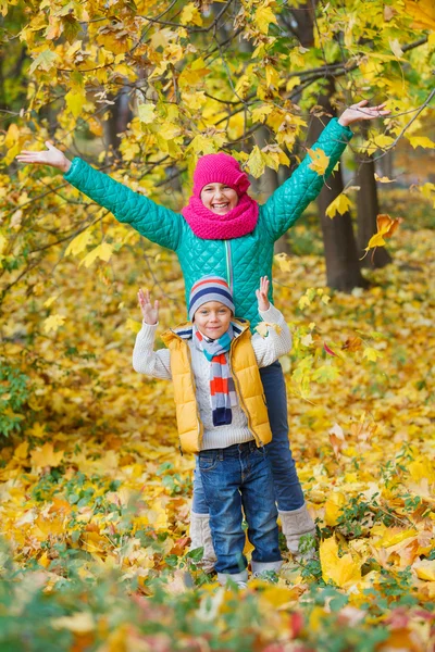 Niedliche Kinder mit Herbstblättern — Stockfoto