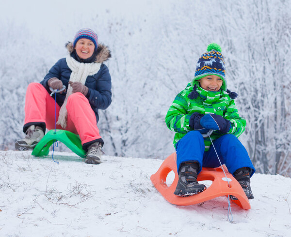 Family having fun with sled in winter park