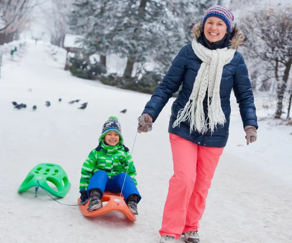 Familie plezier met slee in winter park — Stockfoto