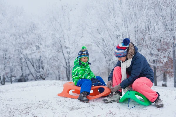 Familie plezier met slee in winter park — Stockfoto