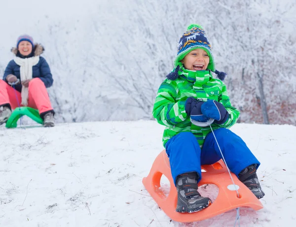 Kleiner Junge hat Spaß mit Schlitten im Winterpark — Stockfoto