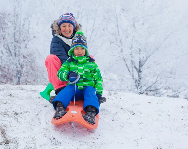 Familjen har roligt med släde i Vinterparken — Stockfoto