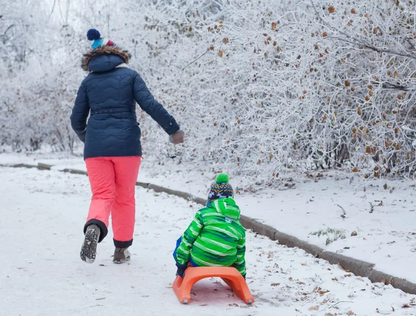 Familjen har roligt med släde i Vinterparken — Stockfoto