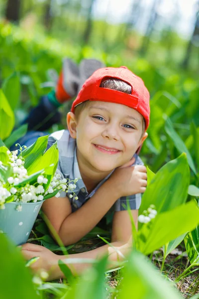 Boy with lilies of the valley — Stock Photo, Image