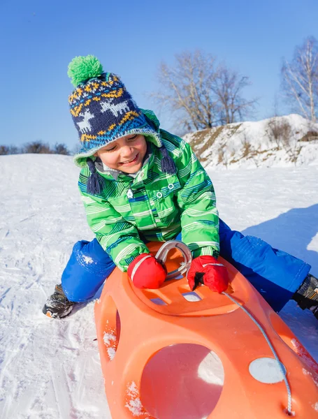 Liten pojke att ha kul med släde i Vinterparken — Stockfoto