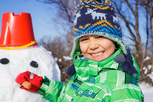 Niño con un muñeco de nieve —  Fotos de Stock