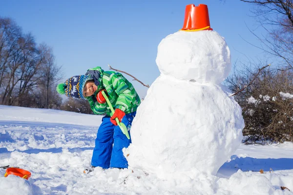 Ragazzo con un pupazzo di neve — Foto Stock