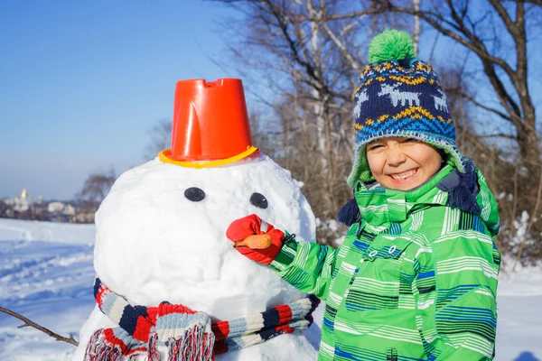 Junge mit einem Schneemann — Stockfoto