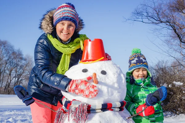 Familie baut Schneemann — Stockfoto