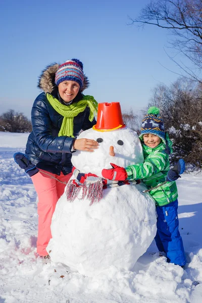 Familjen bygga snögubbe — Stockfoto