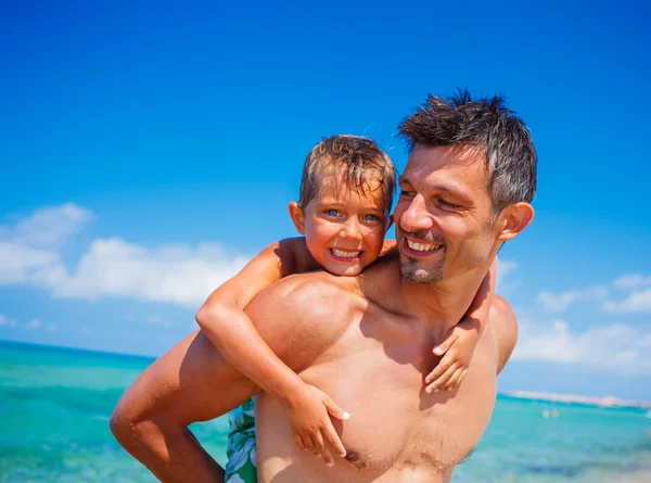 Far och son på stranden — Stockfoto