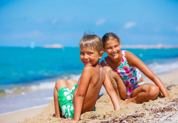 Garçon avec sa sœur sur la plage — Photo