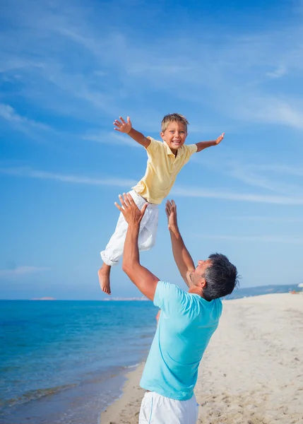 Far och son på stranden — Stockfoto