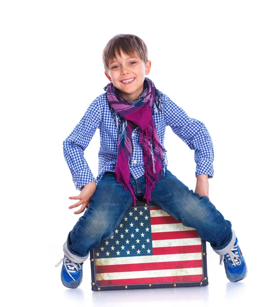 Boy sitting on a case. — Stock Photo, Image