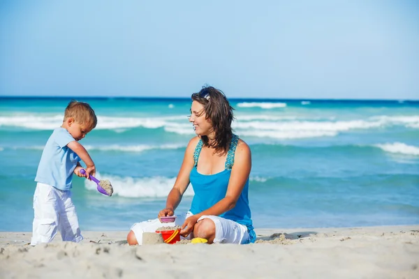 Mor och son leker på stranden — Stockfoto